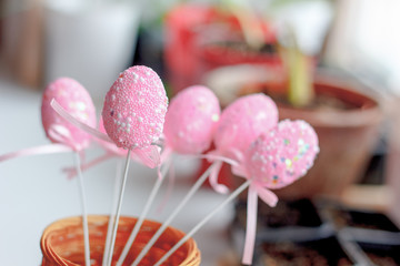 Pink easter eggs on a sticks over the bright background.