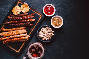 beer snacks. bar table. restaurant, pub, oktoberfest. variety of delicious appetizers. homemade grilled sausages with mug of lager and sauces. friday party atmosphere, craft brewery concept