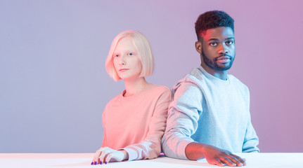 young people without emotions,attractive girl and man are members of pestiferous sect, close up photo, isolated blue background