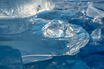 Pieces of clear blue ice of lake Baikal in the winter sunlight. Beauty of nature