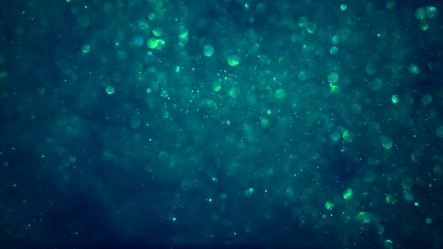 Abstract teal blue sparkly particle background with shiny bokeh lights LOOP.