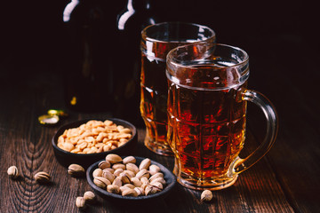 bar table. two mugs of lager beer and snacks set. restaurant, pub food. delicious drink and salty nuts. oktoberfest atmosphere, craft brewery concept