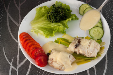 Cod with Velouté sauce on a white plate