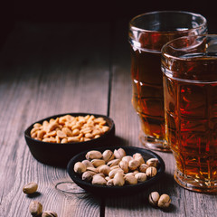 bar table. two mugs of lager beer and snacks set. restaurant, pub, food concept. delicious drink and salty nuts. oktoberfest atmosphere, craft brewery background