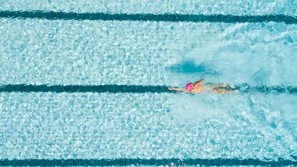 Aerial image of a beautiful female swimmer in a swimming pool getting ready to train.