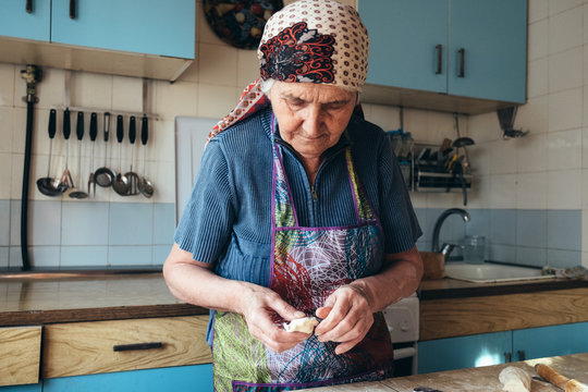 Grandmother cooking, preparing sweet dumpling with cottage cheese