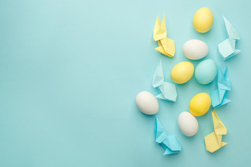 Top view shot of arrangement decoration Happy Easter holiday background concept.Flat lay colorful bunny eggs with origami paper accessory blue paper at office desk. Design pastel tone