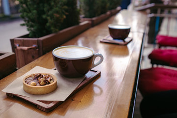 two cups of coffee cappuccino with baked dessert on wooden table