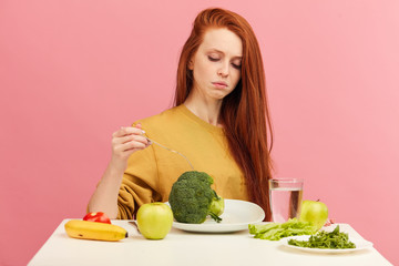 Symptoms of anorexia manifested in aversion to food. Portrait of grimacing unsatisfied facial...