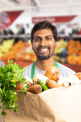 Grocery bag presented by indian employee.