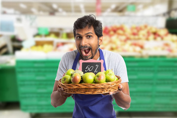 Man working at hypermarket advertising sale at apples.