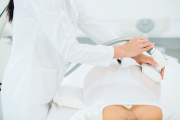 Young brunette female therapist doing beauty therapy against cellulite with LPG machine on woman s buttocks in health and wellness medical clinic. LPG massage for lifting body