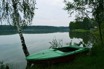 Naklejka na ściany i meble Green boat on the pond