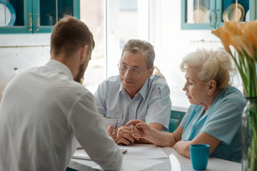 Elderly parents consulting their son