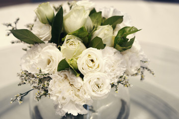 a vase of white roses and carnations