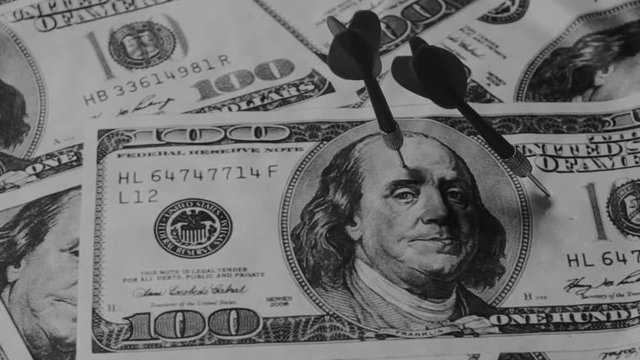 Concept of arrow in target money on dart board ,Dart arrow hitting in bullseye on dartboard with money
