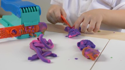 A two years old preschool child playing with modeling clay (compound). Smiling and looking at the camera. Early childhood education to children concept