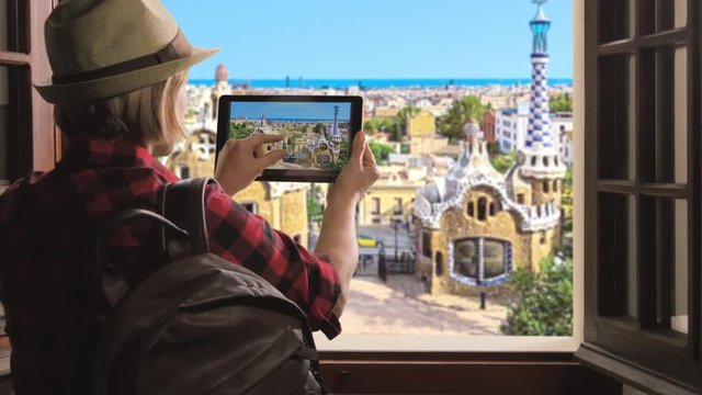 tourist taking pictures of barcelona skyline,woman takes photo of park guell using smartphone
