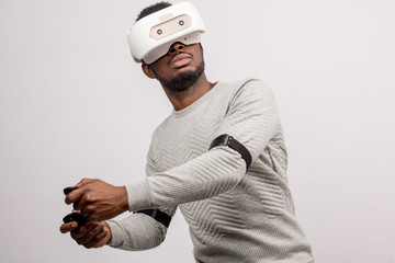 Ethnic dark-skinned bearded male model in virtual reality headset playing tennis in augmented reality. Future. Future technology concept. Isolated on white background.