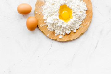 Making dough concept. Pile of flour and eggs on white background top view copy space