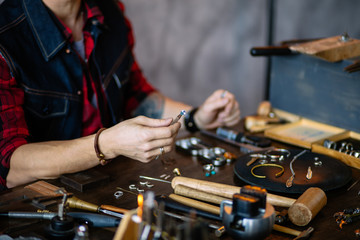 Professional jeweler sitting at workplace, close up cropped photo. neatly work, occupation concept