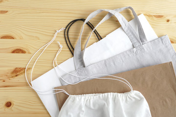 Shopping bags on wooden background. Cotton and paper bags for free plastic shopping.