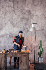 craftsman repairing bracelets in the room with gray wall. full length photo. copy space.