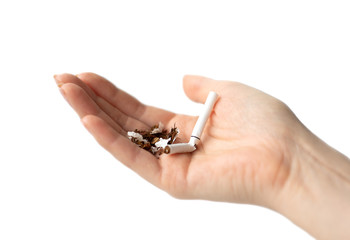 broken cigarette on palm close up on white background
