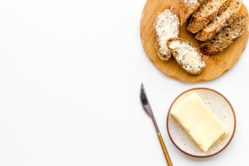 Slice of bread with butter on white background top view copy space
