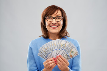 savings, finances and people concept - smiling senior woman holding hundreds of dollar money banknotes