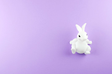 Toy Easter white bunny on a light purple background.