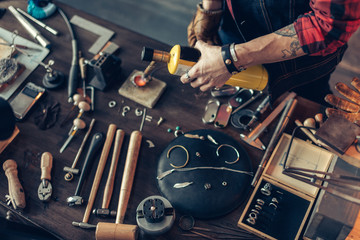 man creating a jewellery at workshop . close up top view photo