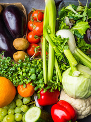 Arrangement of different colorful tasty vegetables and berries on grey concrete rough background. Horizontal. Healthy Food Concept. Food background,