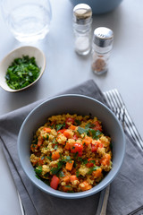Healthy vegan bowl with quinoa, pumpkin, pepper and carrot on gray wooden background. Selective focus