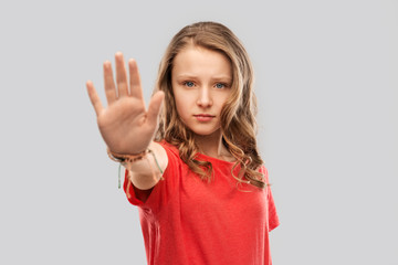 warning, prohibition and people concept - serious teenage girl in blank red t-shirt showing stop gesture over grey background - obrazy, fototapety, plakaty