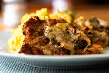 Pork neck gratinated with cheese, mashed potato on plate.