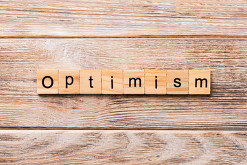 Optimism word written on wood block. Optimism text on wooden table for your desing, concept