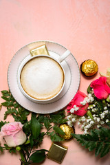 Fototapeta na wymiar Cup of coffee with flowers on pink