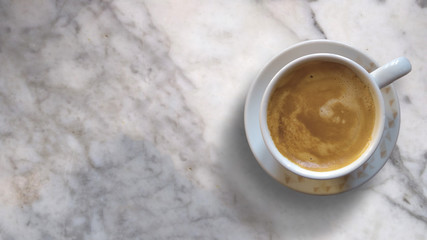 Mug with hot coffee on a marble table. Top view background and empty copy space for Editor's text.