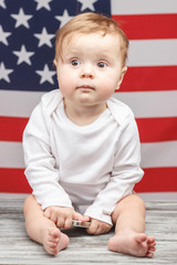 Naklejka premium Child with a phone on the American flag background