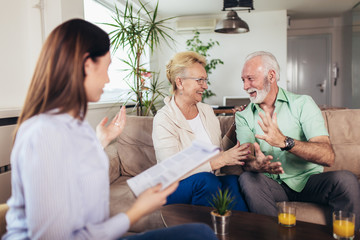 Obraz premium Positive aged couple consulting with insurance agent