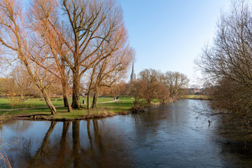 Fototapeta na wymiar Salisbury, Wiltshire, England, UK, February 2019. The Bishops Grounds and River Avon overlooked by Salisbury Cathedral during winter.