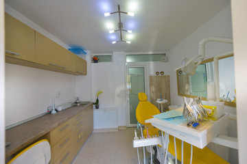 AA small dental office with a yellow chair