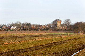 Fototapeta na wymiar Old traditional church and fields in Hippolytushoef at spring, Hollands Kroon, Netherlands.