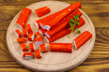 Crab sticks on cutting board on wooden table