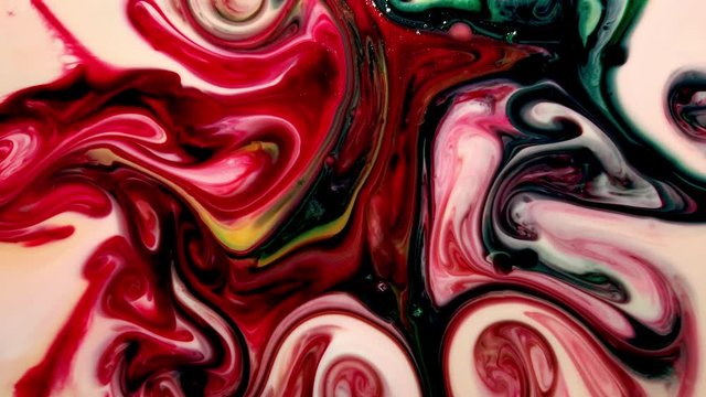 Multiple colors of food coloring dye swirl and mix together to form a psychedelic pattern in slow motion. ABSTRACT, SLOWMO, 4K.