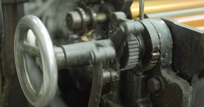 Cogs turning the ink rollers on a letterpress printing machine. An old printing press gear system. Slow Motion.