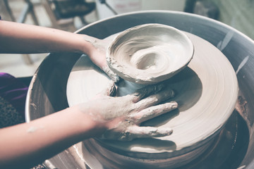 young potter hands working with clay on pottery wheel