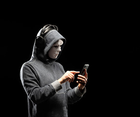 Fototapeta premium Computer hacker in white mask and hoodie. Obscured dark face. Data thief, internet fraud, darknet and cyber security concept.