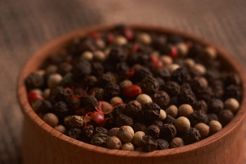 Peppercorns in a wooden bowl on table with food rustic style. Homemade food